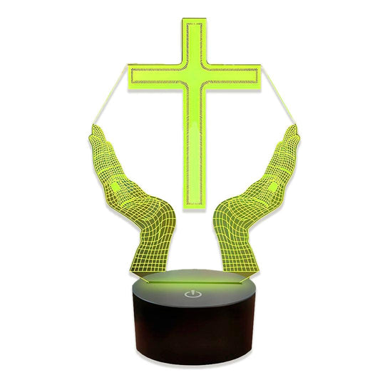 Cruz iluminada em verde-limão sobre duas mãos abertas de malha, em base preta