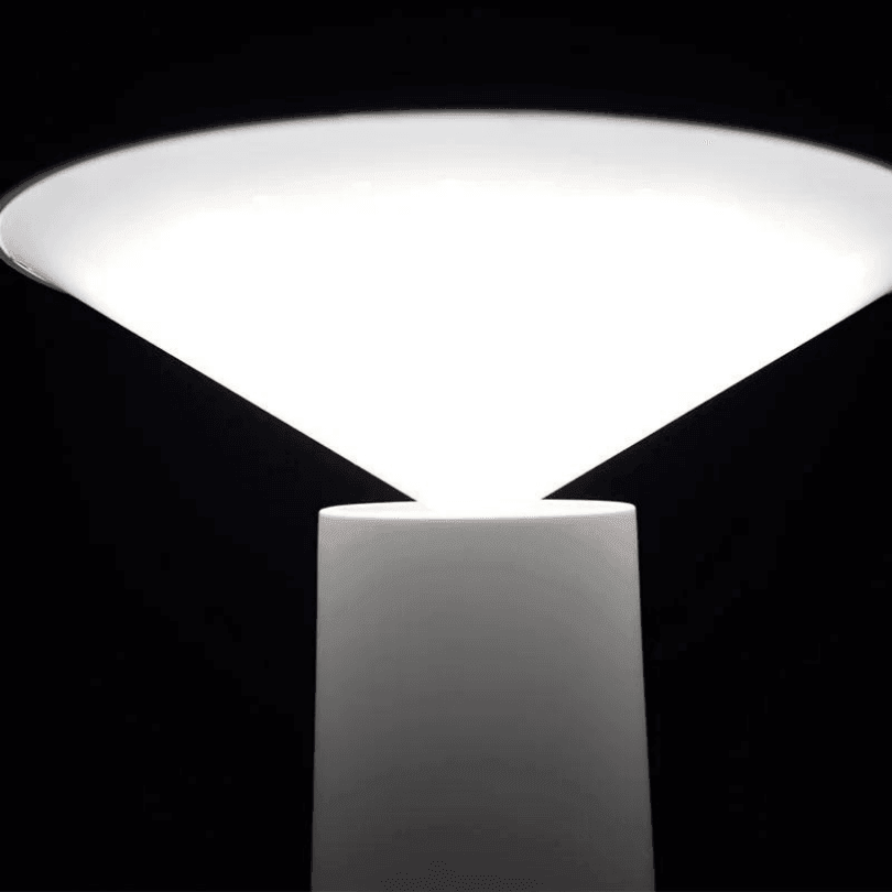Cone aceso em luz branca, visto de perto, sobre a coluna branca em fundo escuro