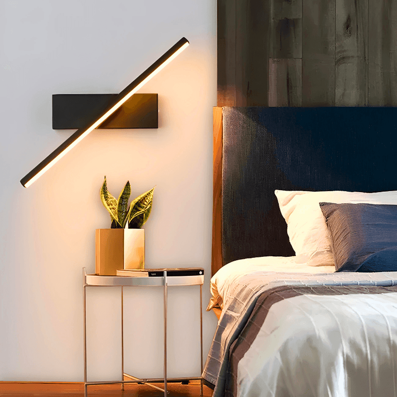 Arandela linear preta de LED na diagonal ao lado da cama, acesa em luz quente