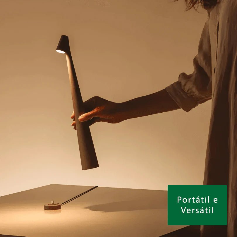 Pessoa segurando a peça marrom pela haste, com a luz acesa na cabeça