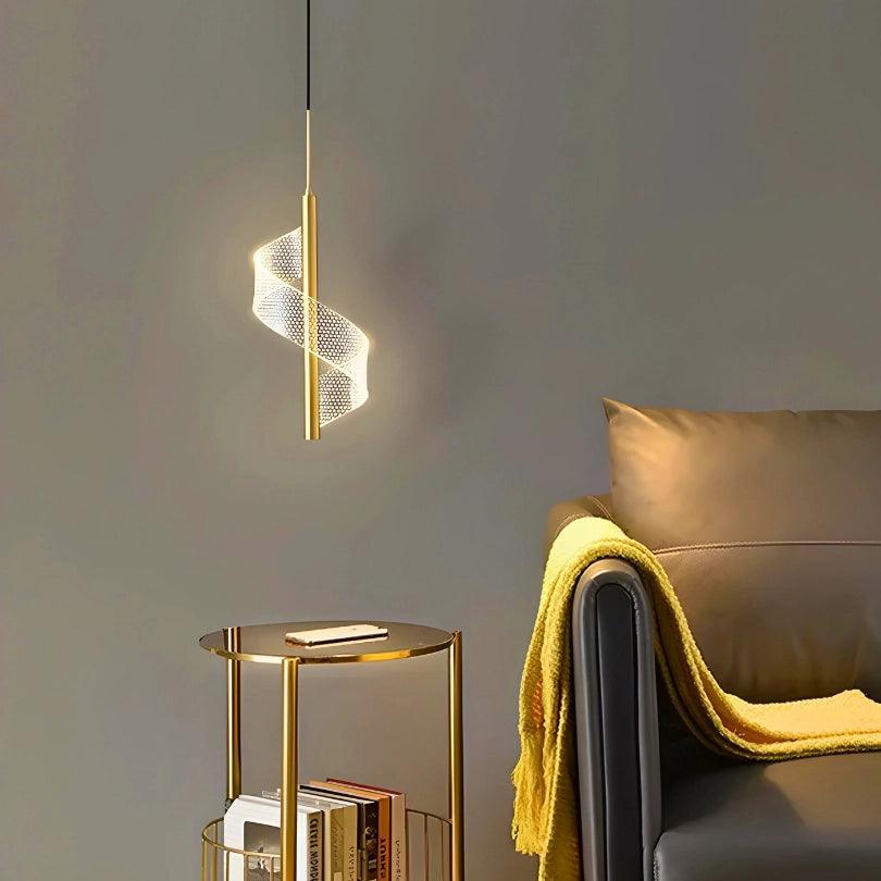 Pendente dourado aceso ao lado de um sofá cinza com manta amarela e mesa lateral