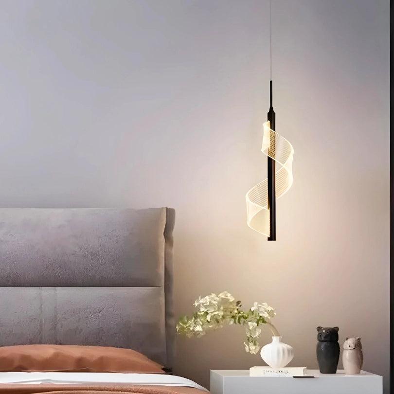 Pendente preto aceso ao lado de uma cama, com flores sobre o criado-mudo