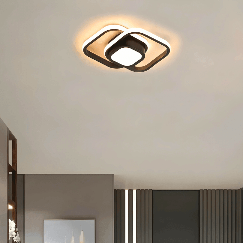 Plafon quadrado de moldura preta aceso no teto de um ambiente, com luz quente
