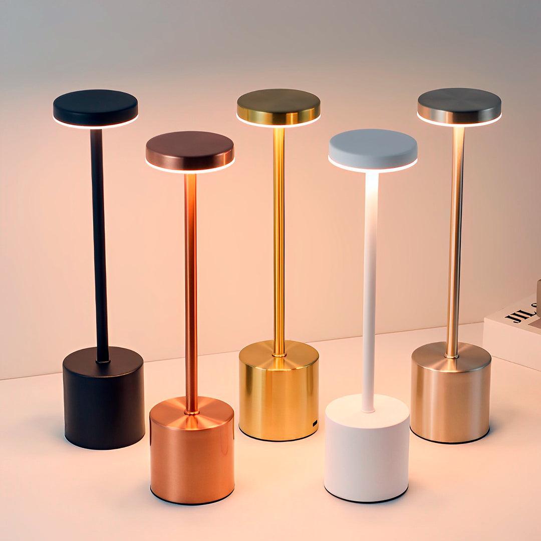 Cinco luminárias de cores diferentes lado a lado, com discos e bases cilíndricas