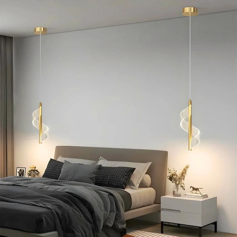 Pendente espiral dourado aceso, um de cada lado de uma cama de cabeceira cinza