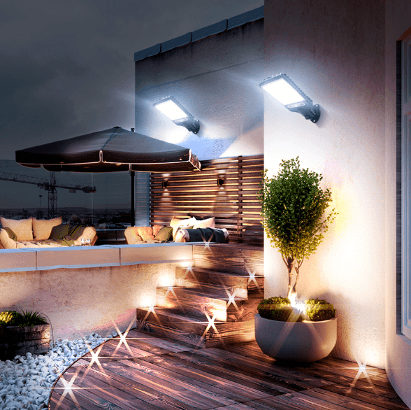 Dois refletores acesos na parede de um terraço, com escada, vaso e ombrelone abaixo