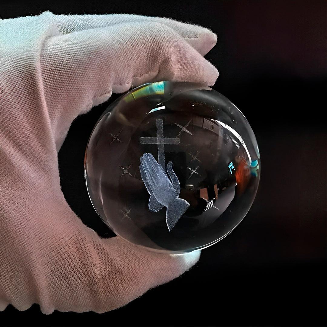 Esfera de vidro com a cruz gravada, segurada numa mão enluvada