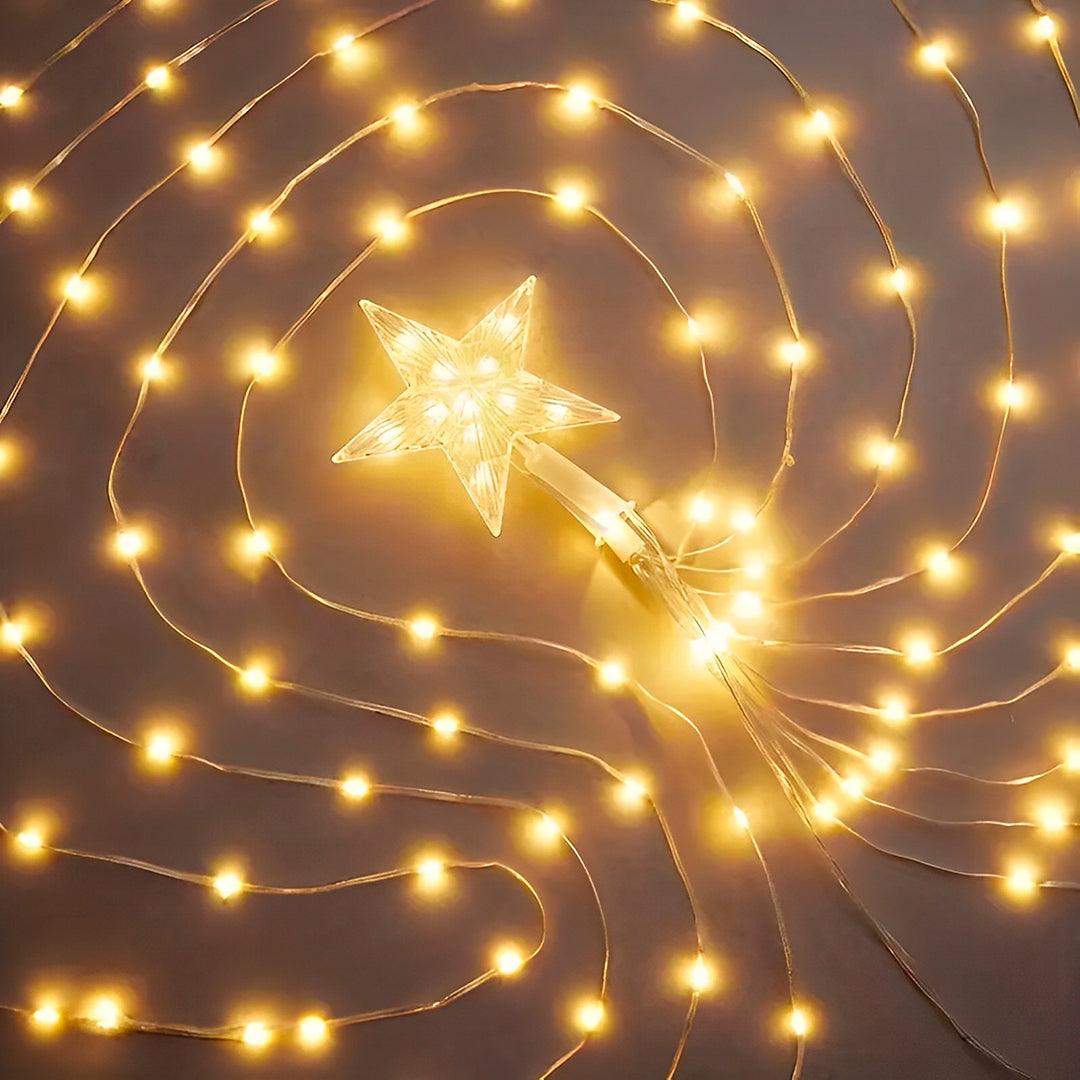 Estrela de LED e fios de cobre com pontos de luz amarela, vistos de cima