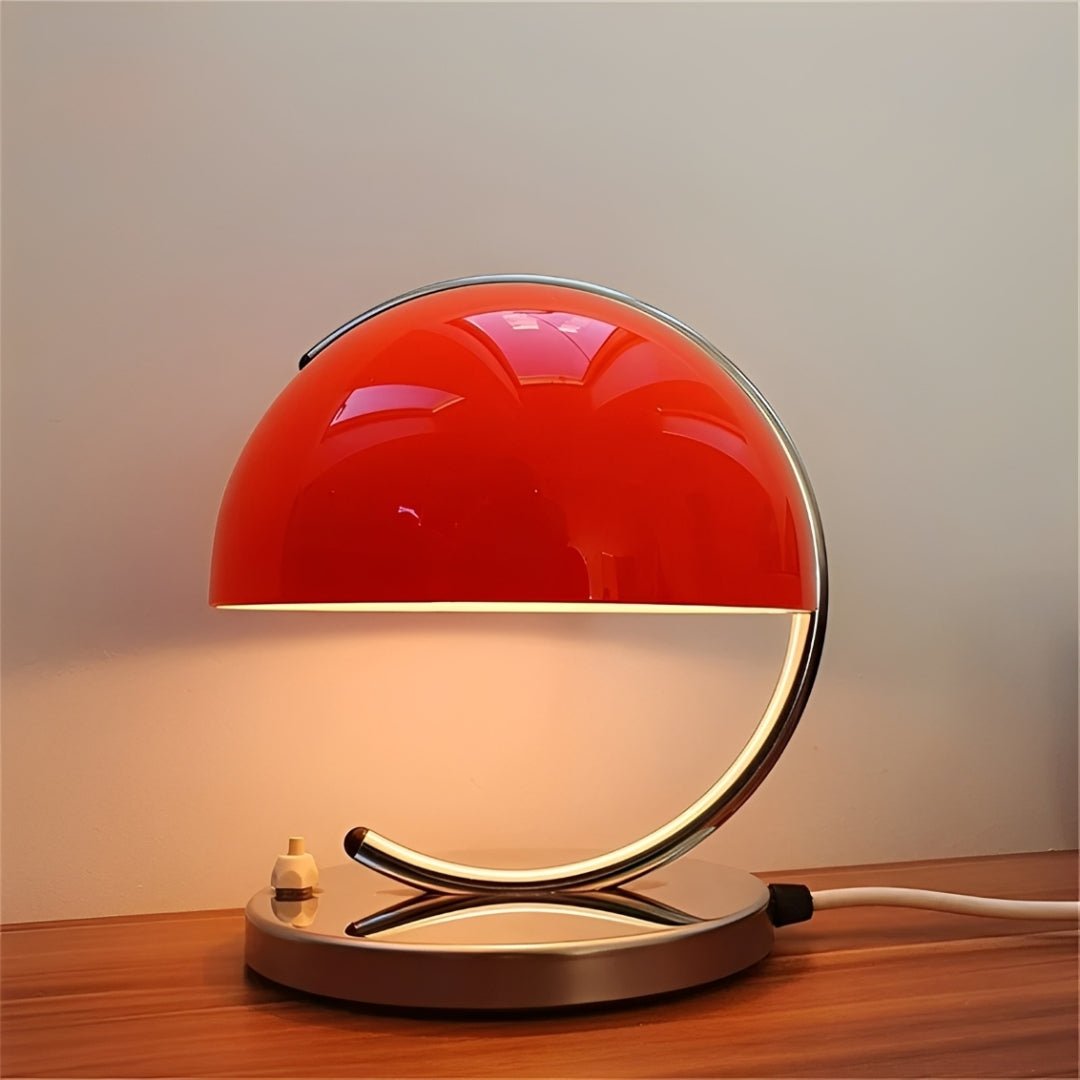 Cúpula vermelha acesa com a luz descendo sobre a base cromada e a mesa