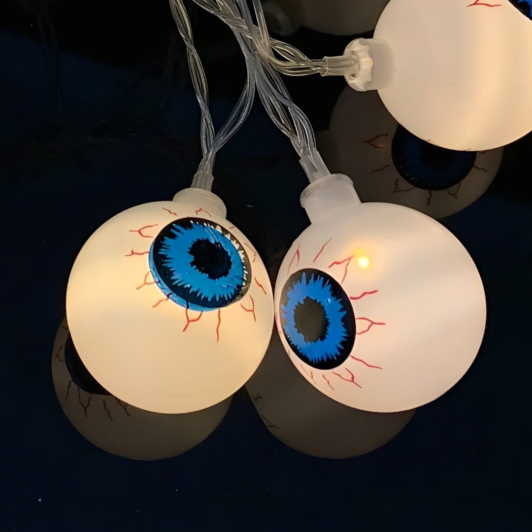 Dois olhos acesos de perto, com íris azul, pupila preta e veias vermelhas pintadas