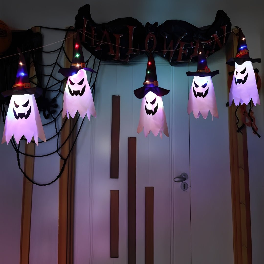 Cinco fantasmas acesos em lilás pendurados num fio sobre uma porta com teia e letreiro