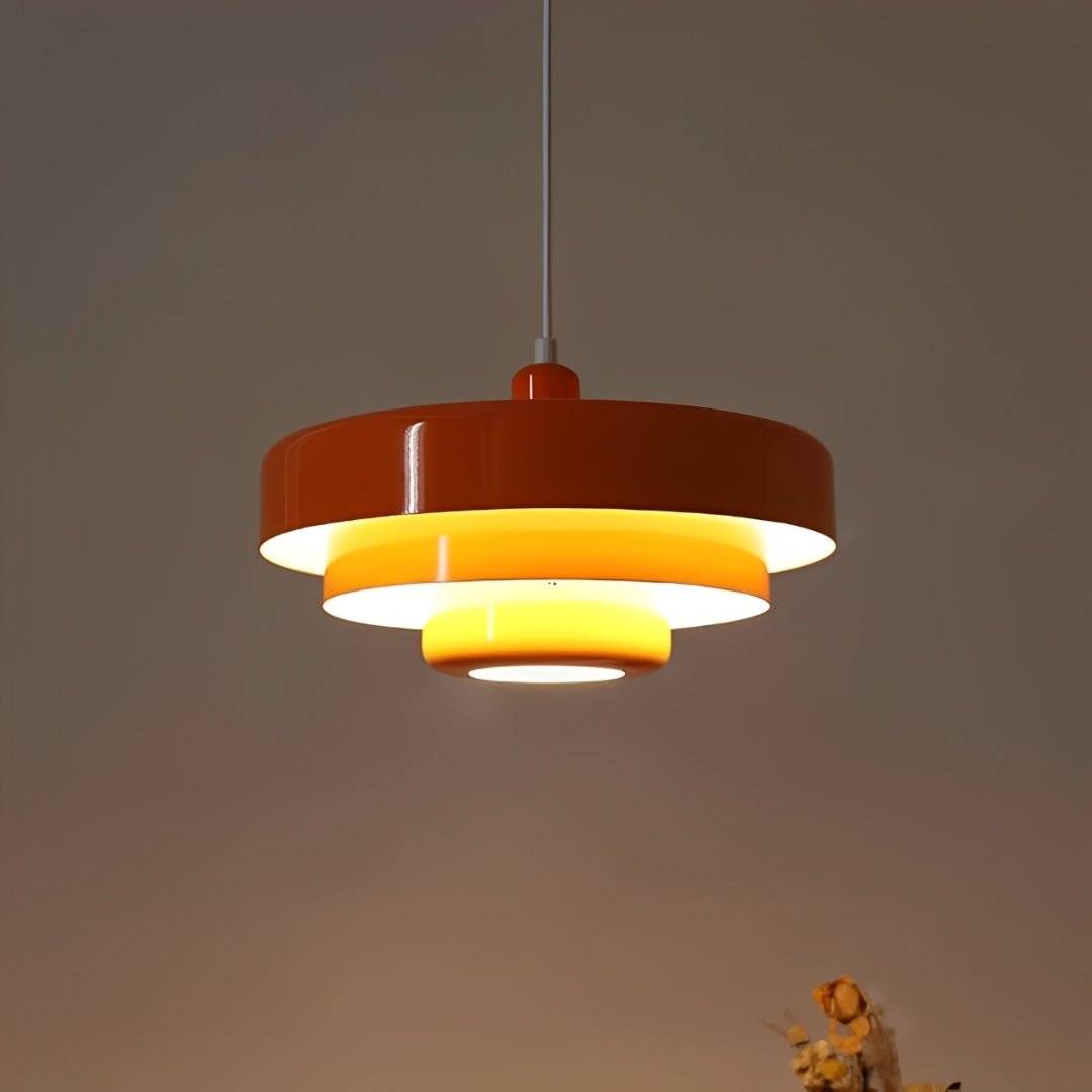 Pendente laranja aceso na penumbra, com a luz saindo entre os níveis