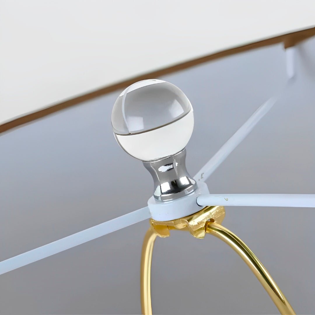 Esfera transparente com pescoço cromado sobre o suporte dourado, vista por baixo da cúpula