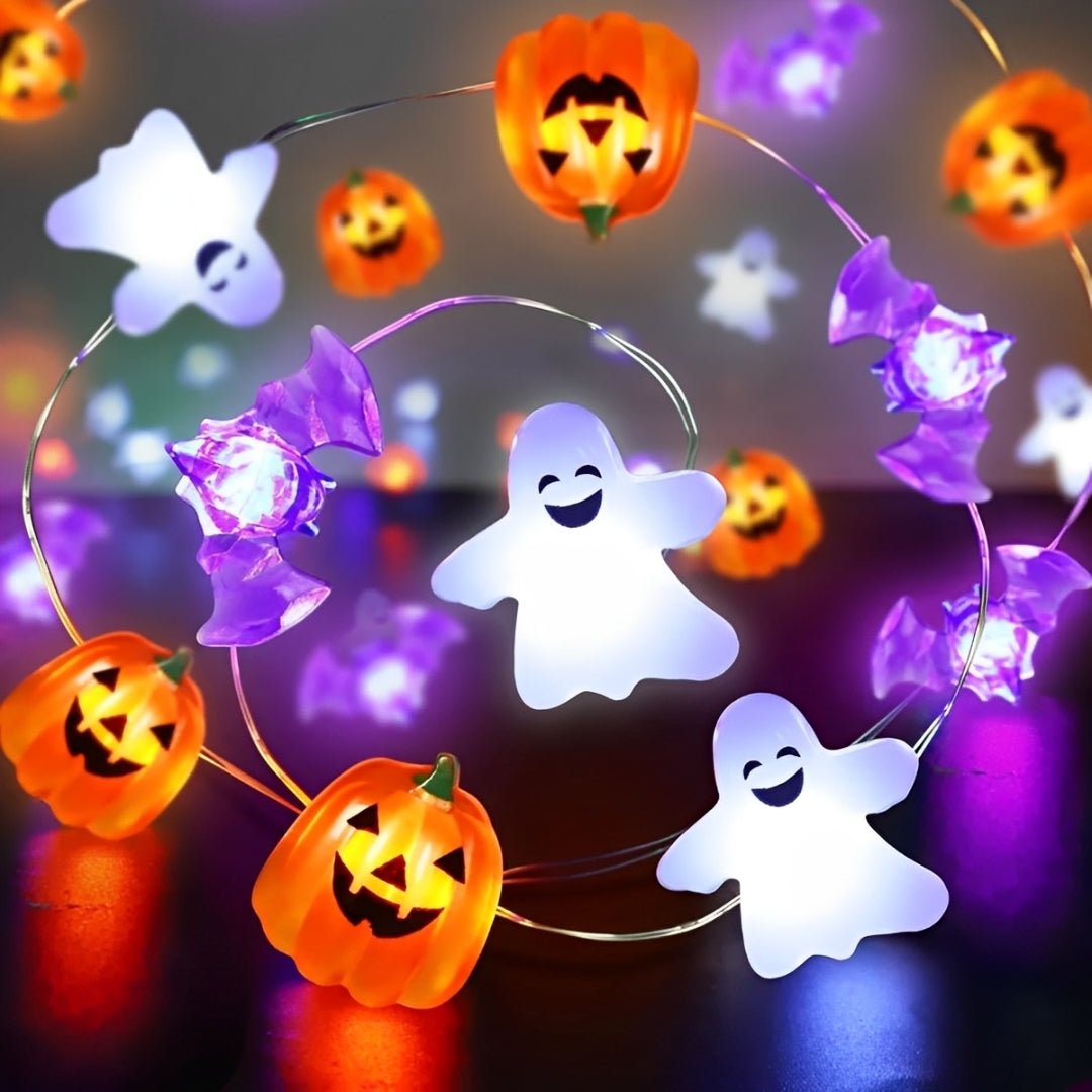 Fantasmas sorridentes, morcegos roxos e abóboras acesas em fio fino formando uma curva