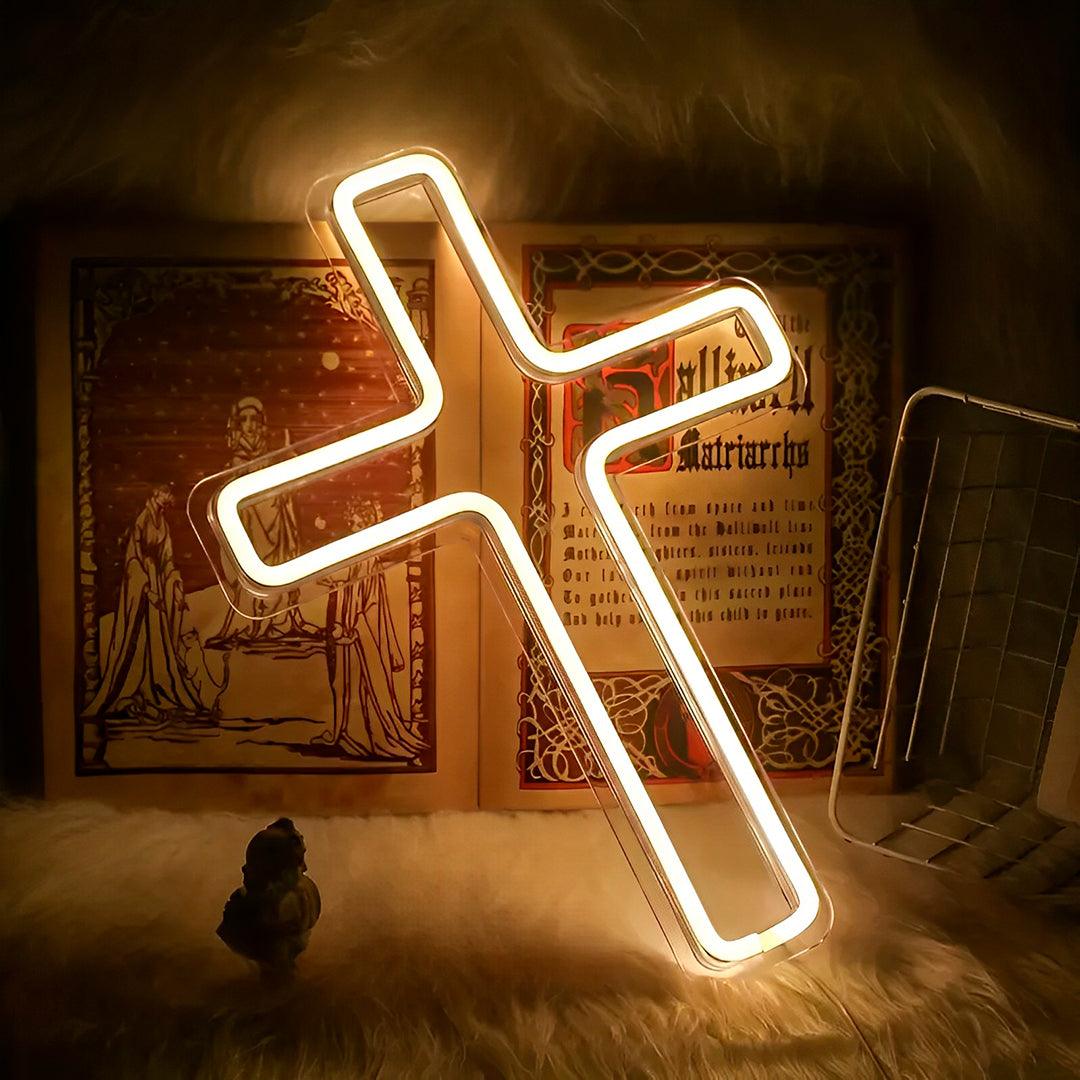 Cruz de neon acesa e inclinada sobre um livro ilustrado, em fundo de pelúcia