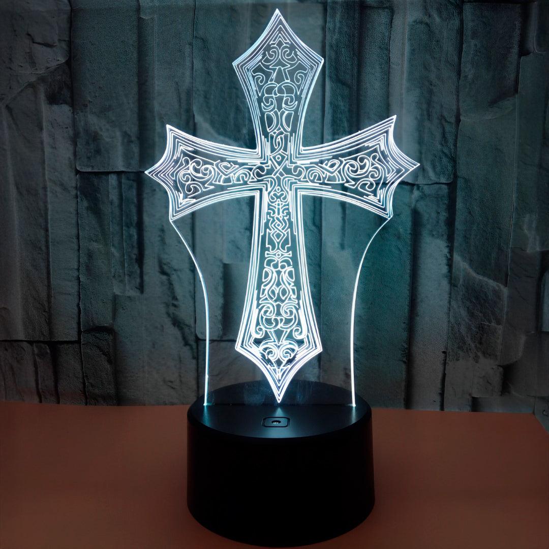 Luminária cruz gótica acesa em branco sobre uma mesa, diante de parede de pedra