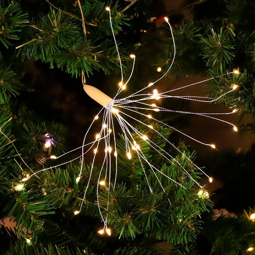 Esfera de fios finos com LEDs acesos entre os galhos de uma árvore de Natal