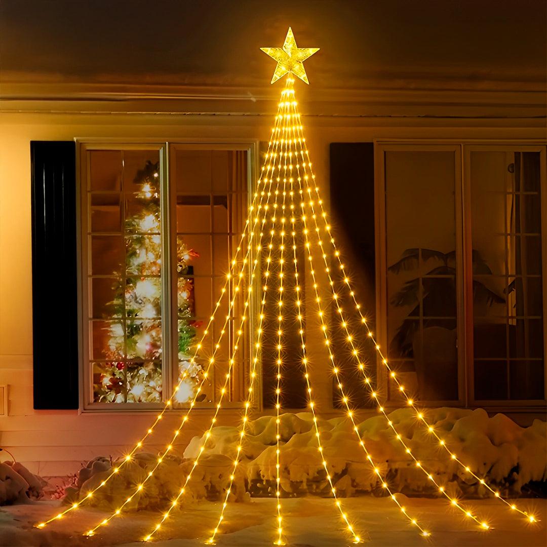 Árvore de pisca-pisca em luz amarela com estrela no topo, na fachada de uma casa