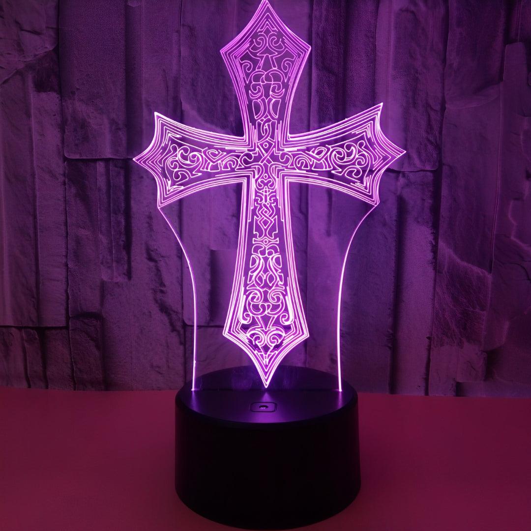 Cruz ornamentada acesa em violeta sobre uma mesa, com a base preta redonda
