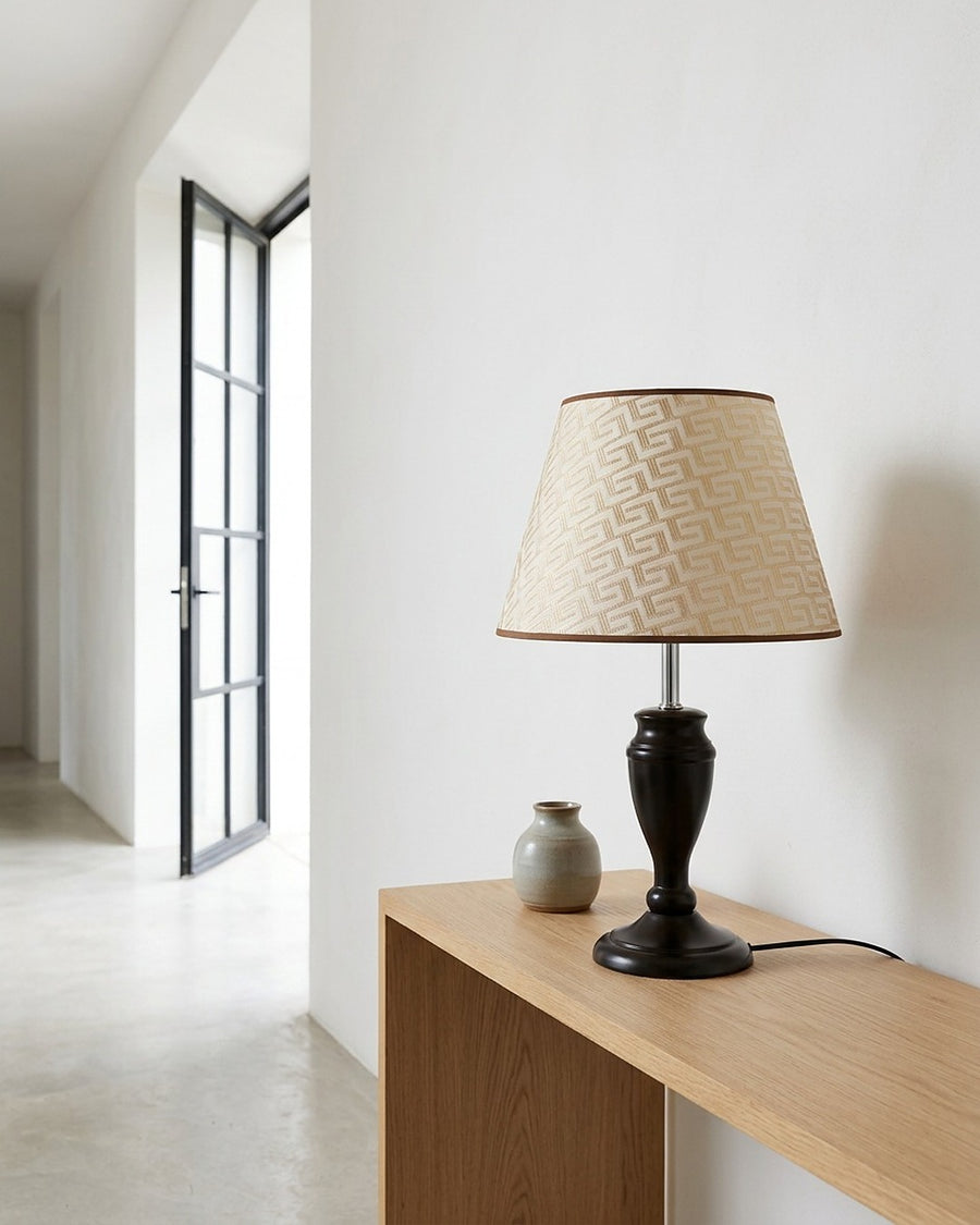 A base de madeira torneada escura sobre o aparador claro