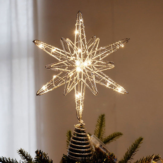 Estrela para árvore de Natal com LED, em arame dourado com glitter, acesa no topo de um pinheiro