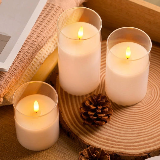 Velas de LED com chama 3D, kit com três velas brancas em copos de vidro sobre bandeja de palha