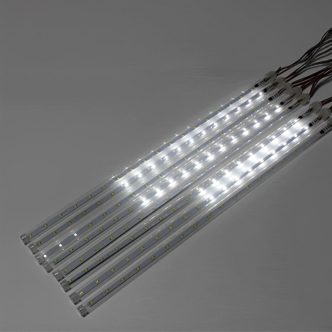 Oito tubos transparentes de luz branca acesos, lado a lado, saindo do mesmo fio