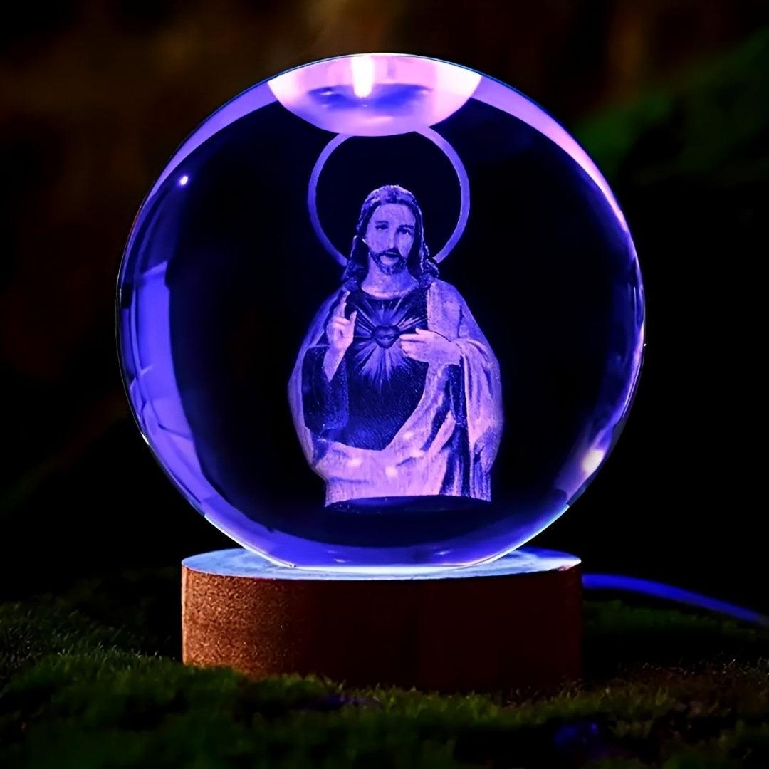 Esfera com Jesus acesa em azul e violeta sobre base de madeira