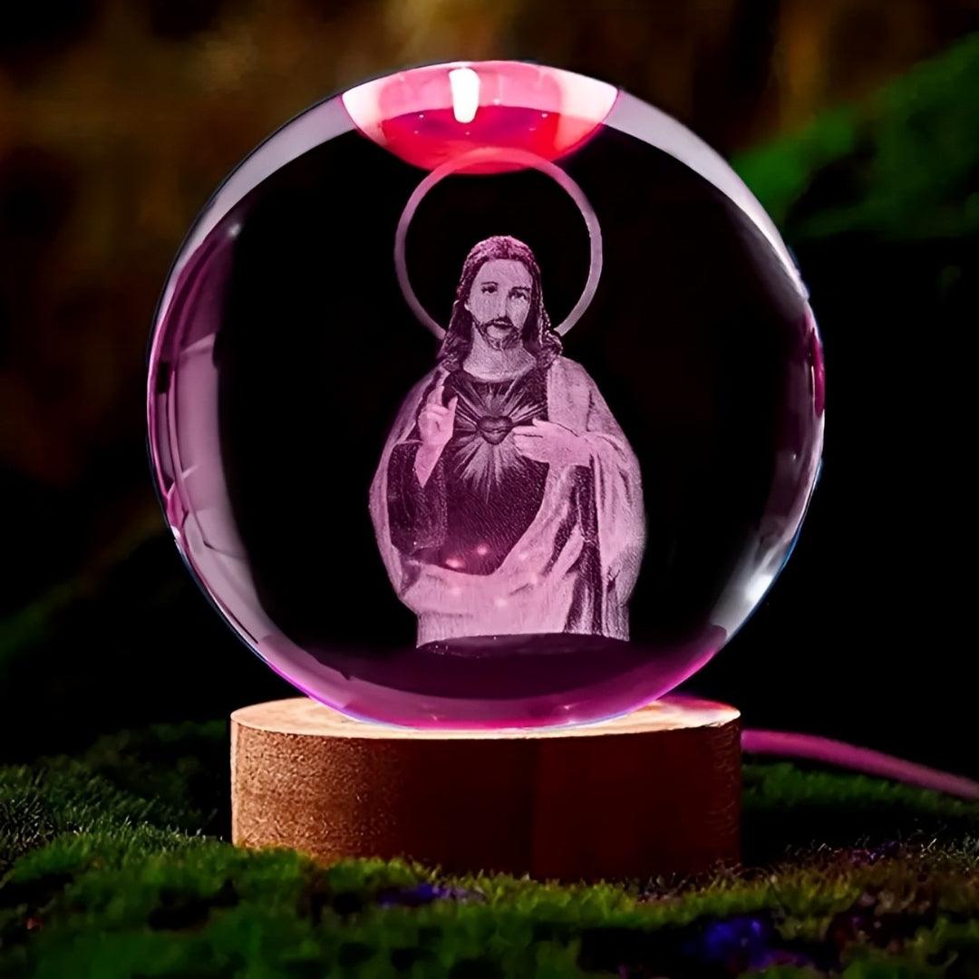 Esfera com Jesus acesa em rosa e vermelho, apoiada sobre musgo