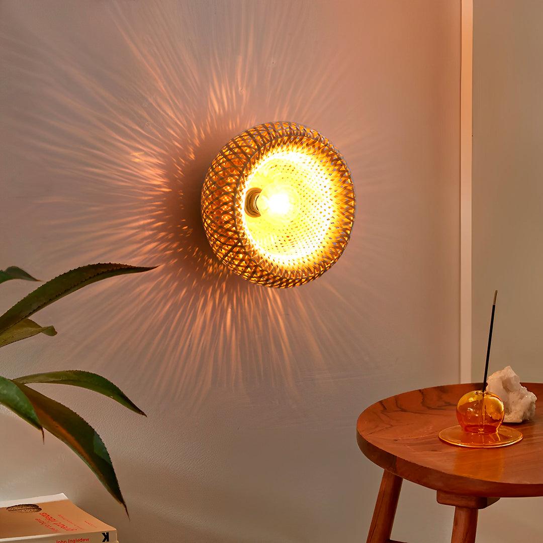 Meia esfera de bambu acesa na parede, com raios de luz e uma mesa