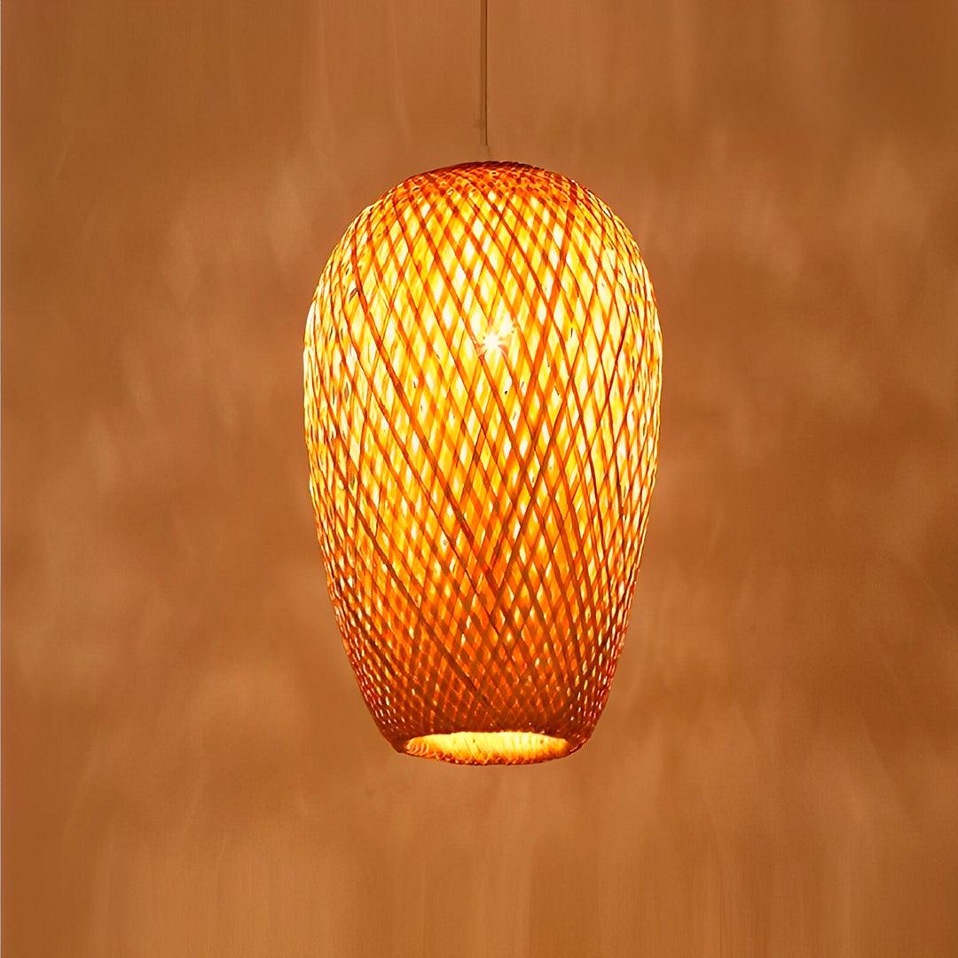 Casulo de bambu aceso diante de parede laranja, com a luz vazando pela trama