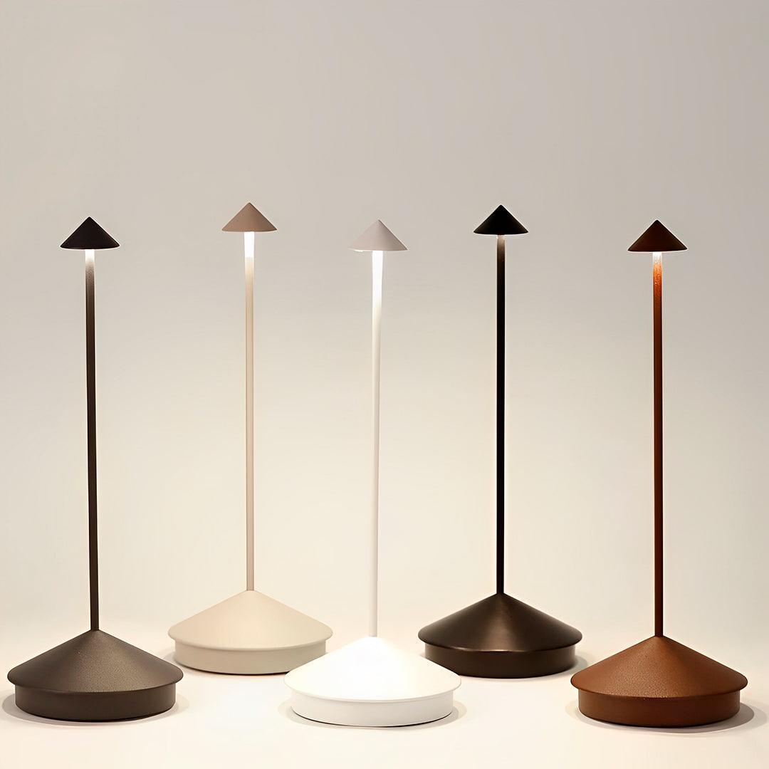 Cinco luminárias de mesa em cores diferentes, com a luz saindo por baixo do chapéu
