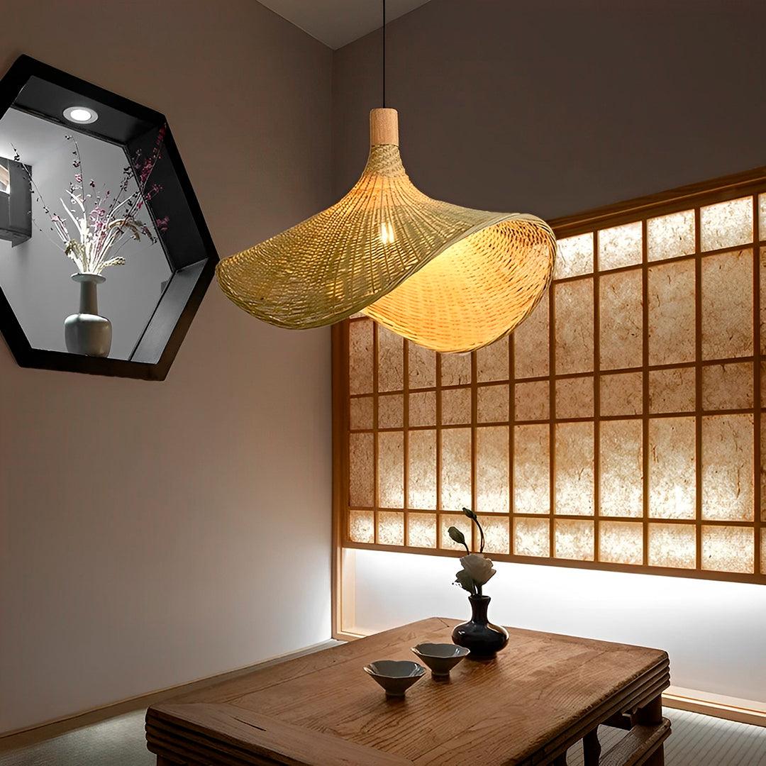 Cúpula de bambu acesa sobre mesa baixa, diante de uma janela de treliça