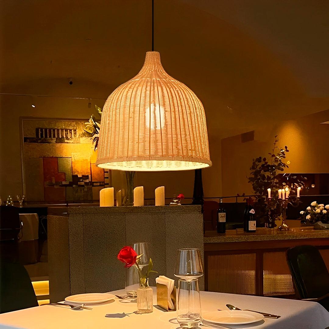 Sino de bambu aceso sobre uma mesa posta de restaurante, com luz quente na trama