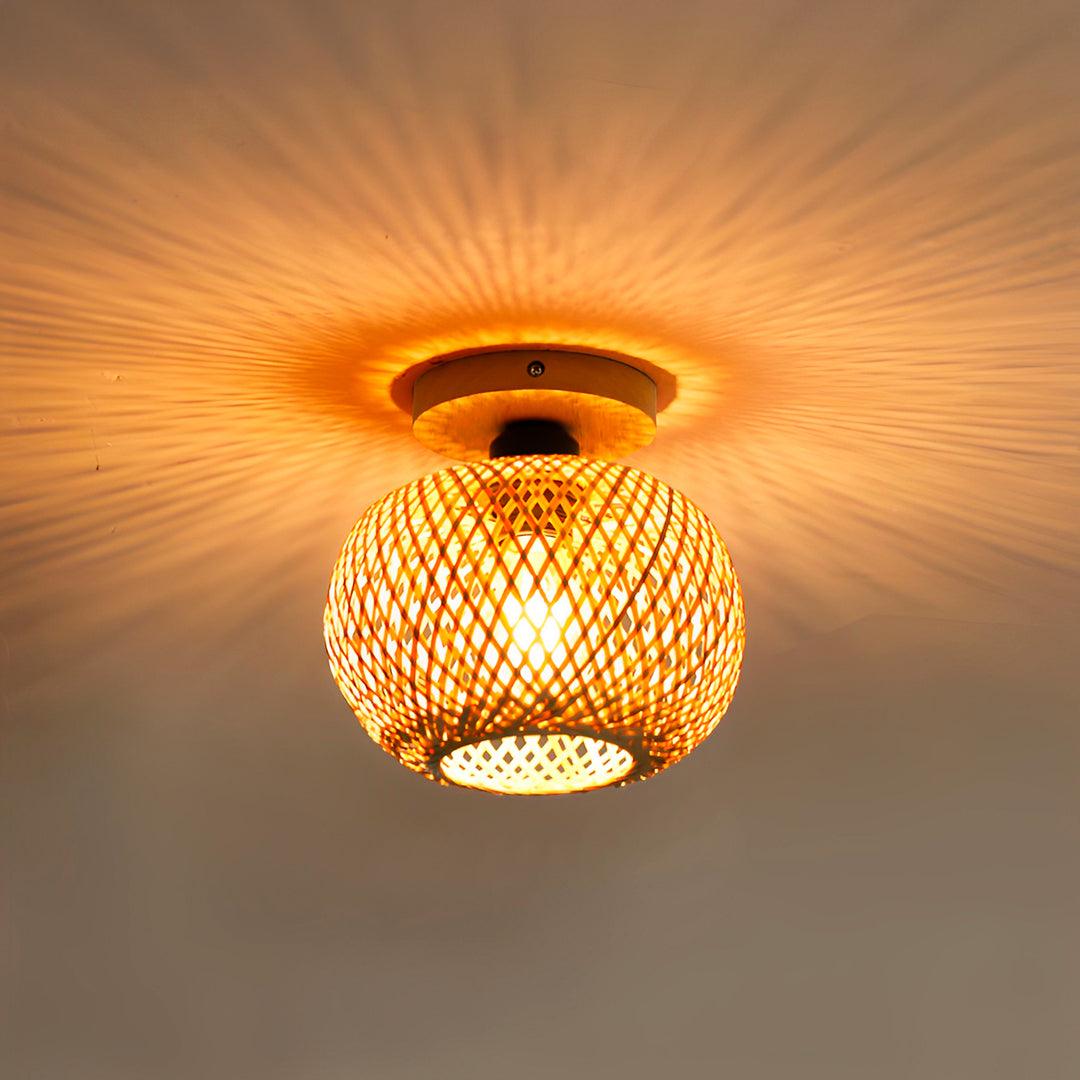 Esfera de bambu acesa de perto, com halo de luz e sombras em volta