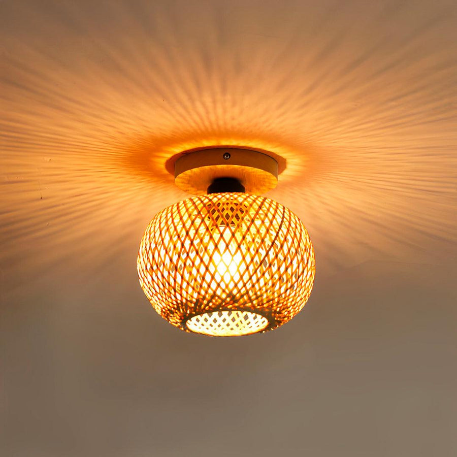 Esfera de bambu acesa de perto, com halo de luz e sombras em volta