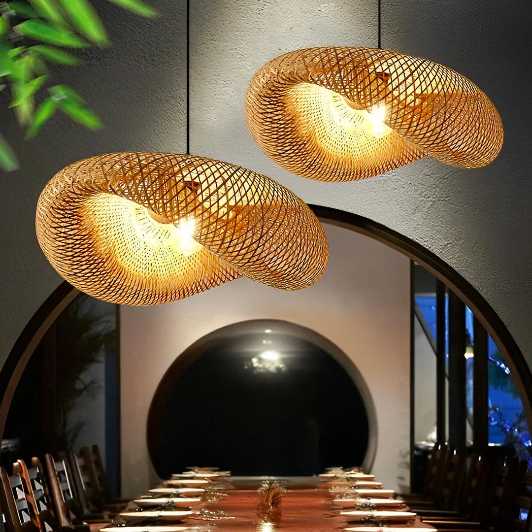 Duas cúpulas de bambu acesas sobre uma mesa comprida, diante de um arco escuro