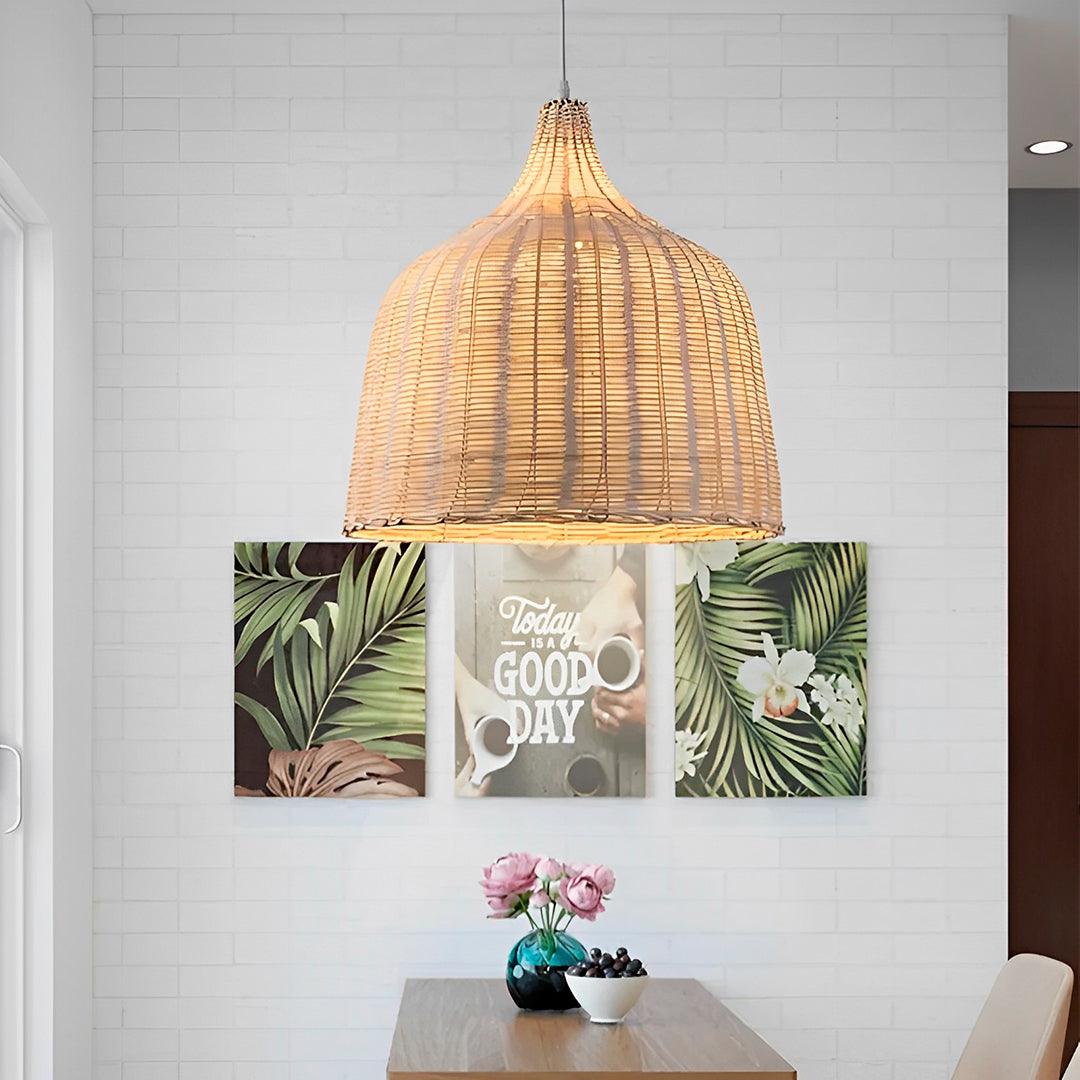 Pendente sino de bambu aceso sobre mesa de jantar, diante de parede de tijolo branco