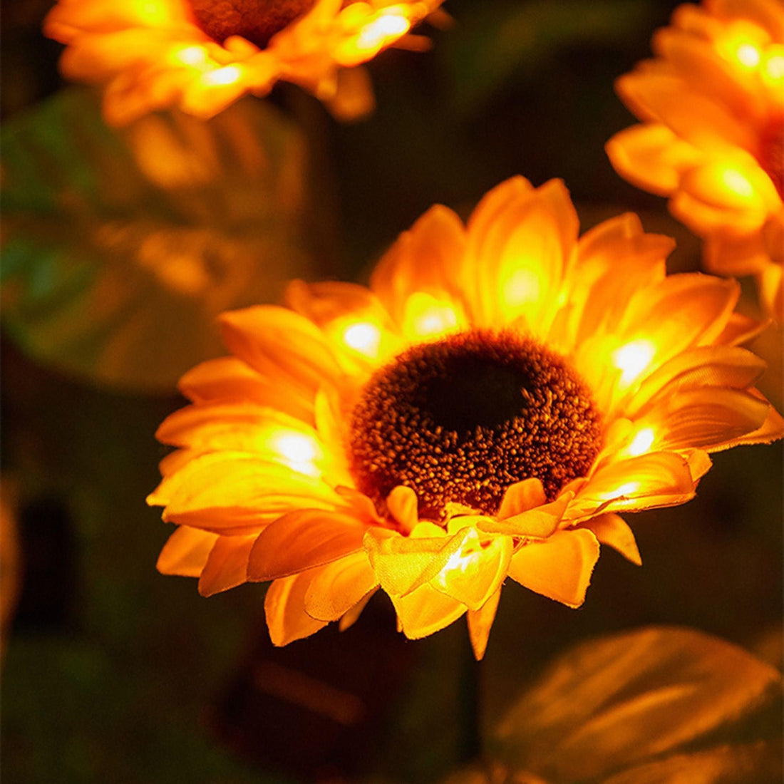 Girassol de LED aceso de perto, com luz amarela em volta do miolo marrom